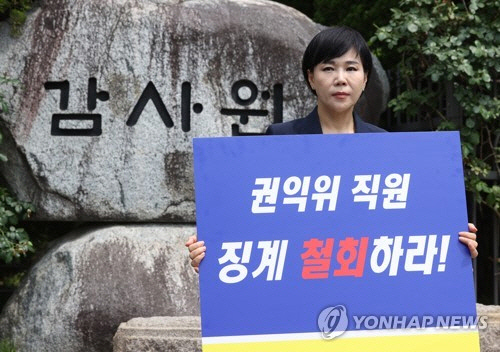 전현희 전 국민권익위원장이 감사원의 최종 감사 결과 발표를 앞둔 지난 6월 9일 서울 종로구 감사원 앞에서 기자회견을 하기 앞서 "권익위 직원 징계 철회하라' 등이 적힌 팻말을 들고 있다. [연합뉴스]